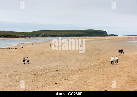 Les gens qui marchent sur la plage de Daymer Bay sur la rivière près de l'estuaire de Camel Rock Cornwall UK en été Banque D'Images