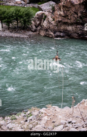 L'homme à l'aide d'un pont sur le plateau de la rivière Gilgit (également connu sous le nom de la rivière Ghizar.) Banque D'Images