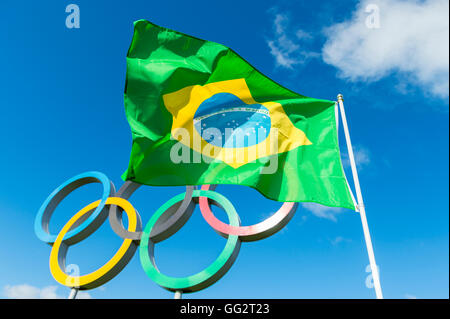 Londres - le 14 octobre 2015 : drapeau brésilien vole à côté pour les anneaux olympiques sous ciel bleu dans le parc Queen Elizabeth. Banque D'Images