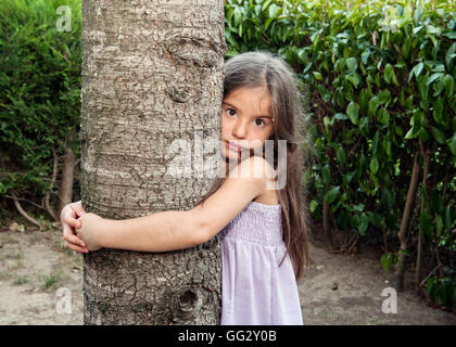 Girl hugging tree Banque D'Images