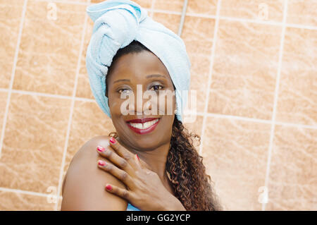 Cette jeune femme africaine en serviette est heureux d'avoir une belle peau Banque D'Images