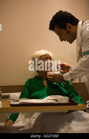 Médecin à son patient d'alimentation Banque D'Images