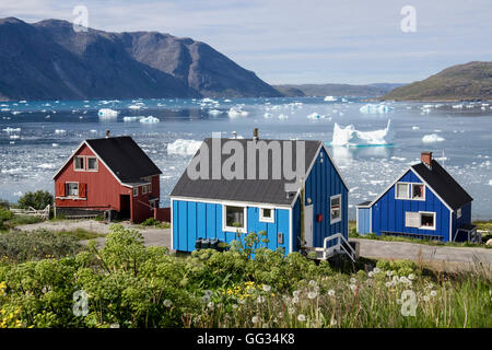 Colorés typiques maisons surplombant le fjord Tunulliarfik Groenlandais d'icebergs flottant au large de la côte du Groenland en été. Narsaq sud du Groenland Banque D'Images