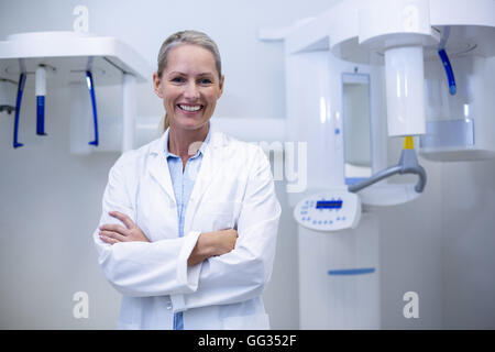 Portrait of female dentist smiling with arms crossed Banque D'Images