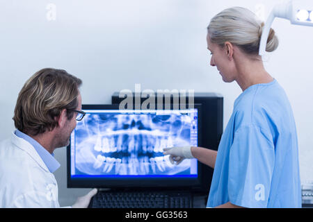 Assistant dentaire dentiste et discuter d'un x-ray sur le moniteur Banque D'Images