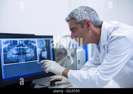 Dentiste réfléchie l'examen d'une x-ray sur le moniteur Banque D'Images