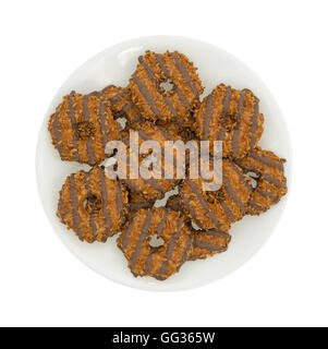 Un groupe de fudge à la noix de coco et caramel cookies sur une plaque isolé sur un fond blanc. Banque D'Images