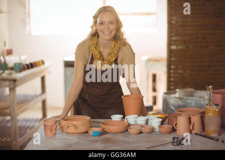Belle femme potter s'appuyant sur le plan de travail Banque D'Images