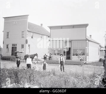Photographie Ancienne c1900, les familles et les devantures de Manistique, Michigan, USA. SOURCE : négatif photographique original. Banque D'Images