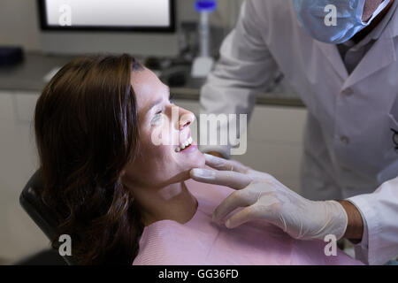 Dentiste de l'examen d'un patient de sexe féminin Banque D'Images