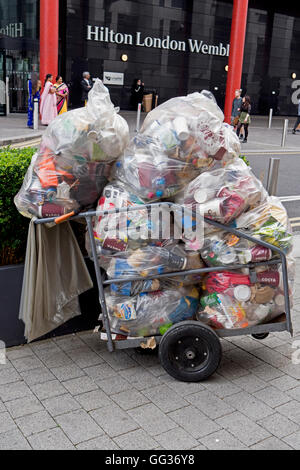 Un chariot plein de sacs poubelle transparent à l'extérieur de l'hôtel Hilton Wembley, l'Angleterre Banque D'Images