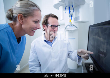 Assistant dentaire dentiste et discuter d'un x-ray sur le moniteur Banque D'Images