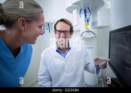 Assistant dentaire dentiste et discuter d'un x-ray sur le moniteur Banque D'Images