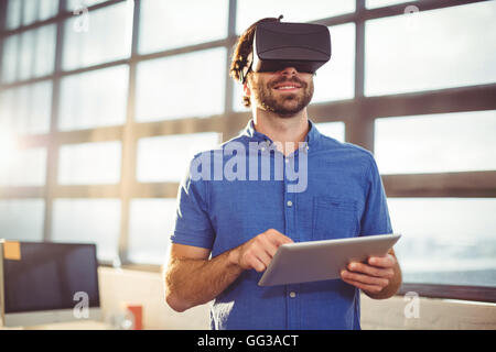 Homme d'affaires dans la région de casque de réalité virtuelle using digital tablet Banque D'Images