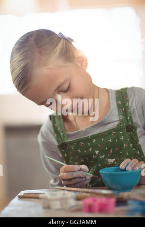 Fille attentionné peinture sur bol Banque D'Images