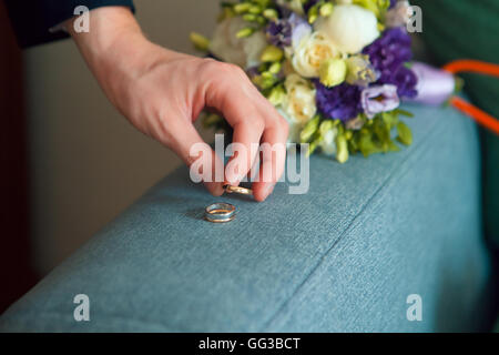 Groom prend l'anneaux d'or à partir de la table Banque D'Images