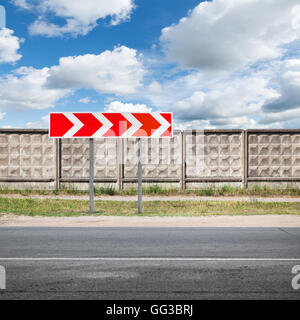 Le rouge et blanc à rayures tour signal routier urbain se trouve près de la route d'asphalte sous ciel nuageux Banque D'Images