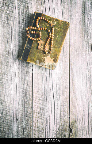 Chapelet et la sainte bible sur la vieille table en bois. Banque D'Images