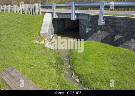 Fossé de drainage s'exécute sous un pont routier Banque D'Images