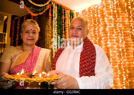 Vieux couple holding a tray de diyas Banque D'Images