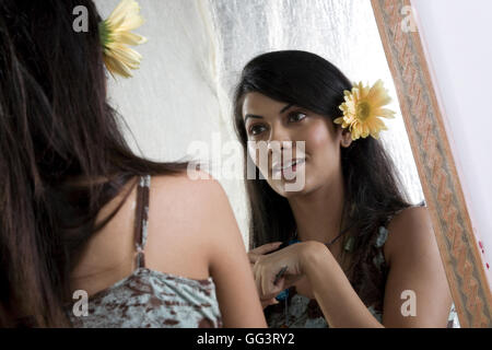 Femme à la recherche dans le miroir Banque D'Images