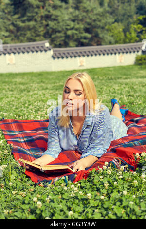 Beautiful smiling woman lying on grass une piscine Banque D'Images