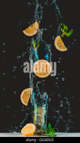 L'antigravité limonade avec le vol des tranches de citron et les éclaboussures d'eau Banque D'Images