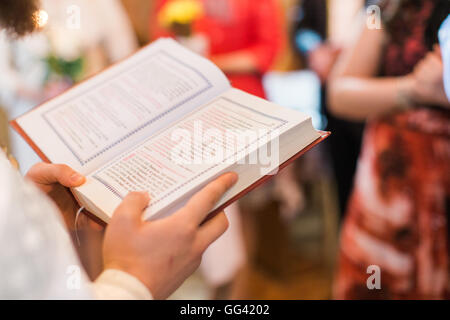 Prêtre orthodoxe au cours de baptême baptême reading book Banque D'Images