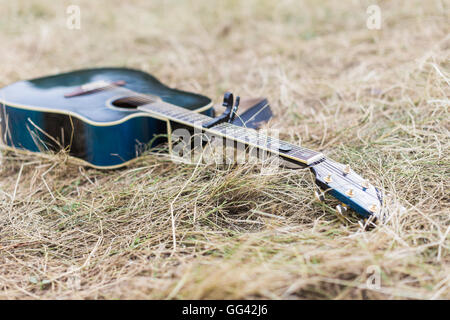 Guitare acoustique en bois bleu lying on grass Banque D'Images