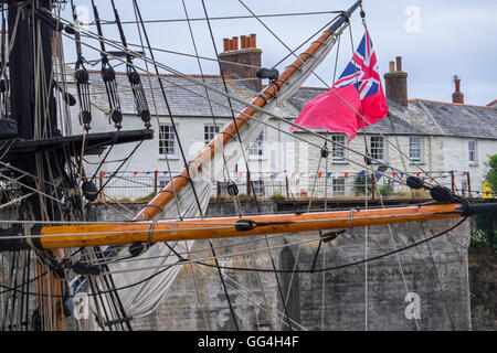 Gréement d'un voilier dans le port de Charlestown, Cornwall, battant pavillon rouge Banque D'Images