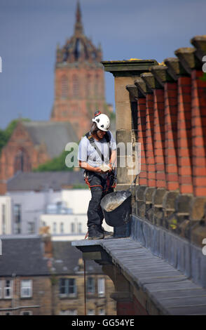 Abseiler travaille sur pierres pointant sur un bâtiment à Paisley, Scotland Banque D'Images