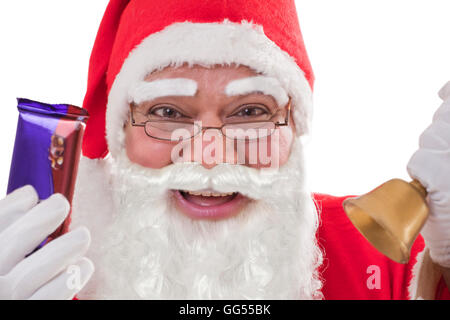 Close-up portrait of cheerful Santa Claus montrant des chocolats avec Bell et verres Banque D'Images