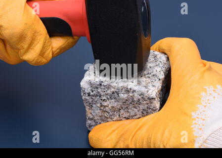 Close-up of hand holding hammer et bloc de pierre Banque D'Images