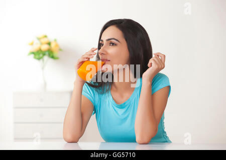 Belle jeune femme à boire le jus d'orange à la maison Banque D'Images