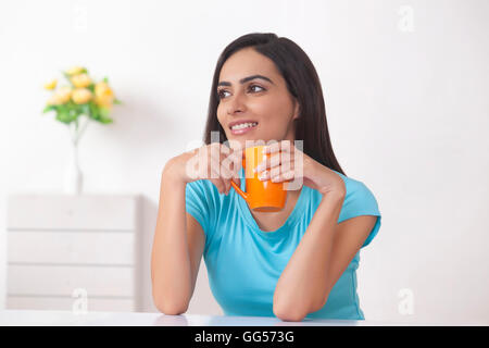 Belle Jeune femme tenant une tasse à café à la maison Banque D'Images