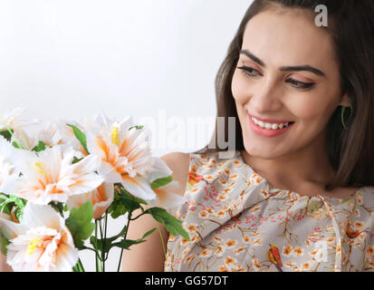 Belle jeune femme avec des fleurs sur fond blanc Banque D'Images