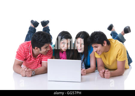 Happy friends using laptop against white background Banque D'Images