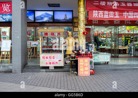 Un vendeur de jus de grenade en face d'une boutique dans la zone de la rue musulmane, Xi'an, Shaanxi, Chine. Banque D'Images