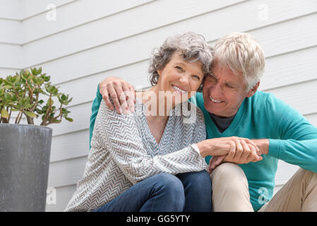 Senior couple assis à l'extérieur de la maison Banque D'Images