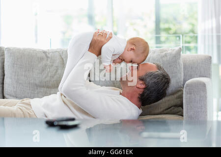 Heureux père jouant avec son mignon bébé fille à la maison