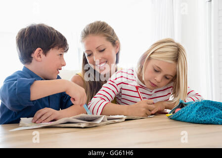 La mère et les enfants à faire des devoirs sur table Banque D'Images
