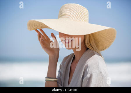 Happy young woman wearing sunhat on beach Banque D'Images