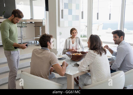 Groupe d'amis assis à table à manger Banque D'Images