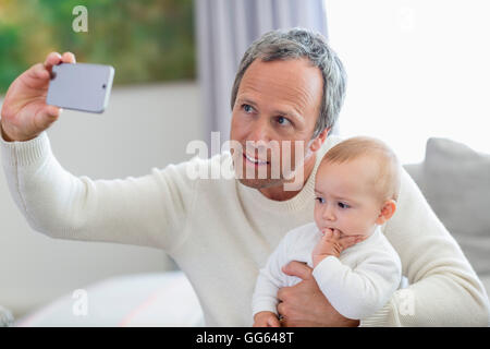 Heureux père avec sa petite fille en tenant avec selfies téléphone appareil photo Banque D'Images