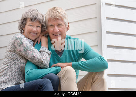 Senior couple assis à l'extérieur de la maison Banque D'Images
