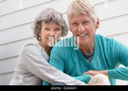Happy senior couple assis à l'extérieur de la maison Banque D'Images