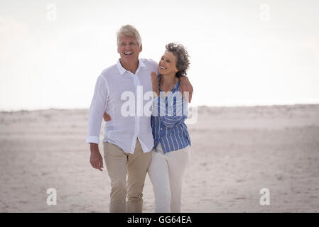 Happy senior couple walking on beach Banque D'Images