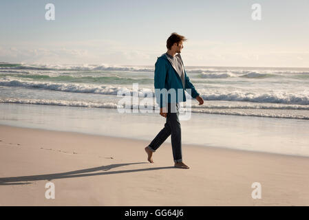 Happy young man walking on beach Banque D'Images