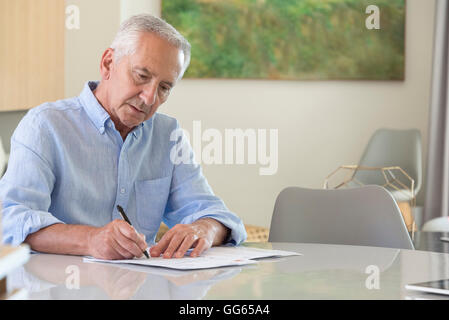 Man doing paperwork at home Banque D'Images