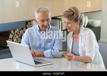 Senior couple shopping online with laptop at home Banque D'Images